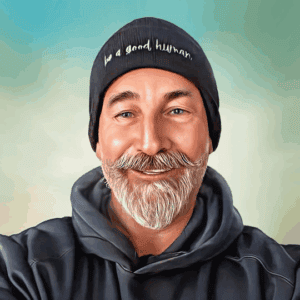 A smiling man with a gray beard and mustache wears the Walk With Us ‘be a good human’ Beanie and a dark hoodie, standing against a soft gradient background.