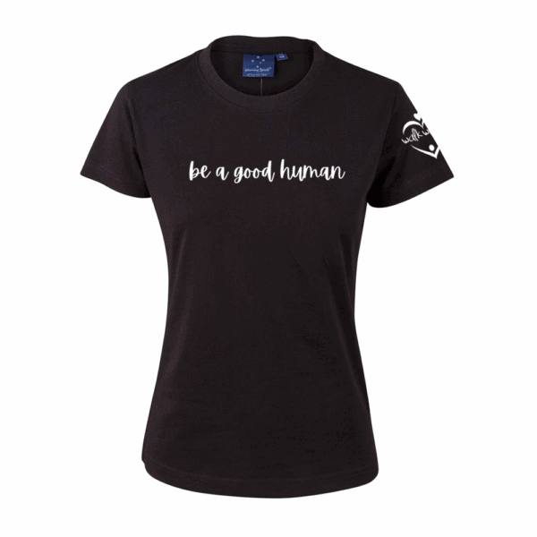 The Ladies Walk With Us Tee is a black short-sleeve t-shirt featuring "be a good human" in white script on the front and a heart with text design on the left sleeve.
